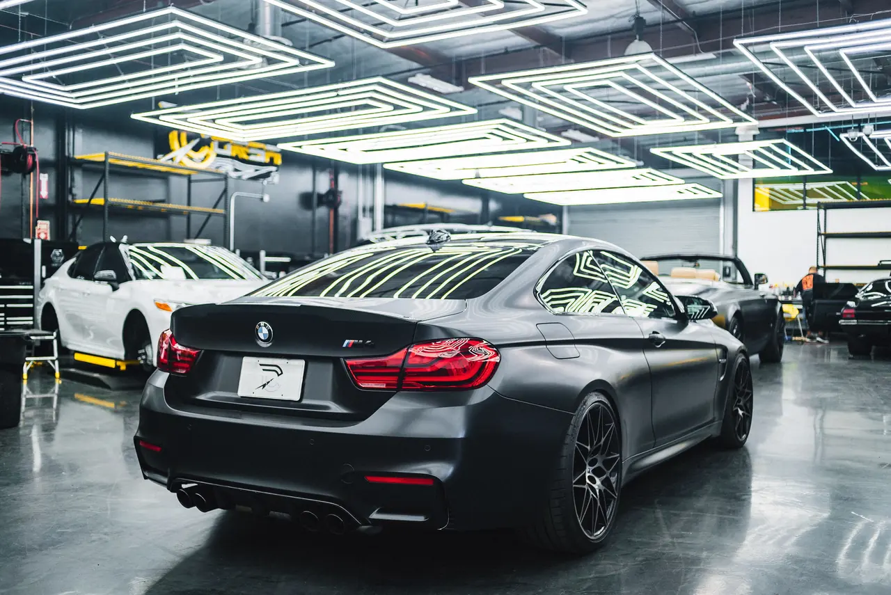 Cars parked indoors under bright workshop lights