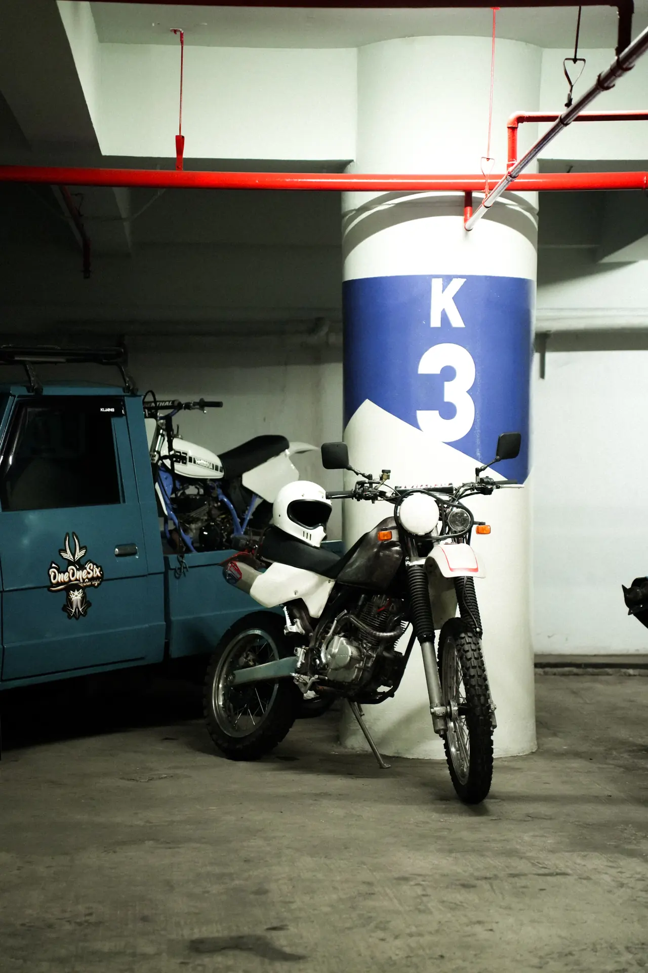 Motorcycle parked indoors beside a concrete column