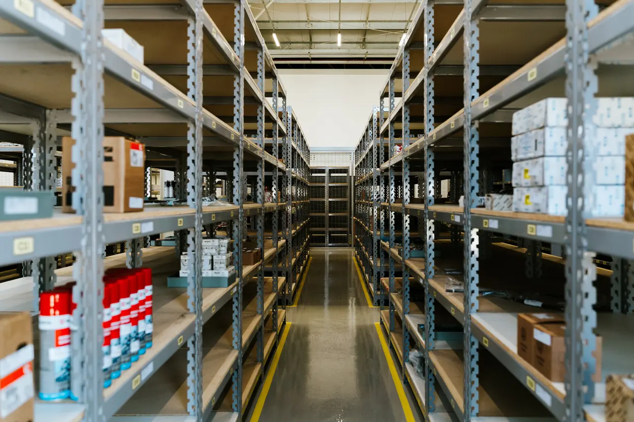 Aisle between tall stocked warehouse shelves